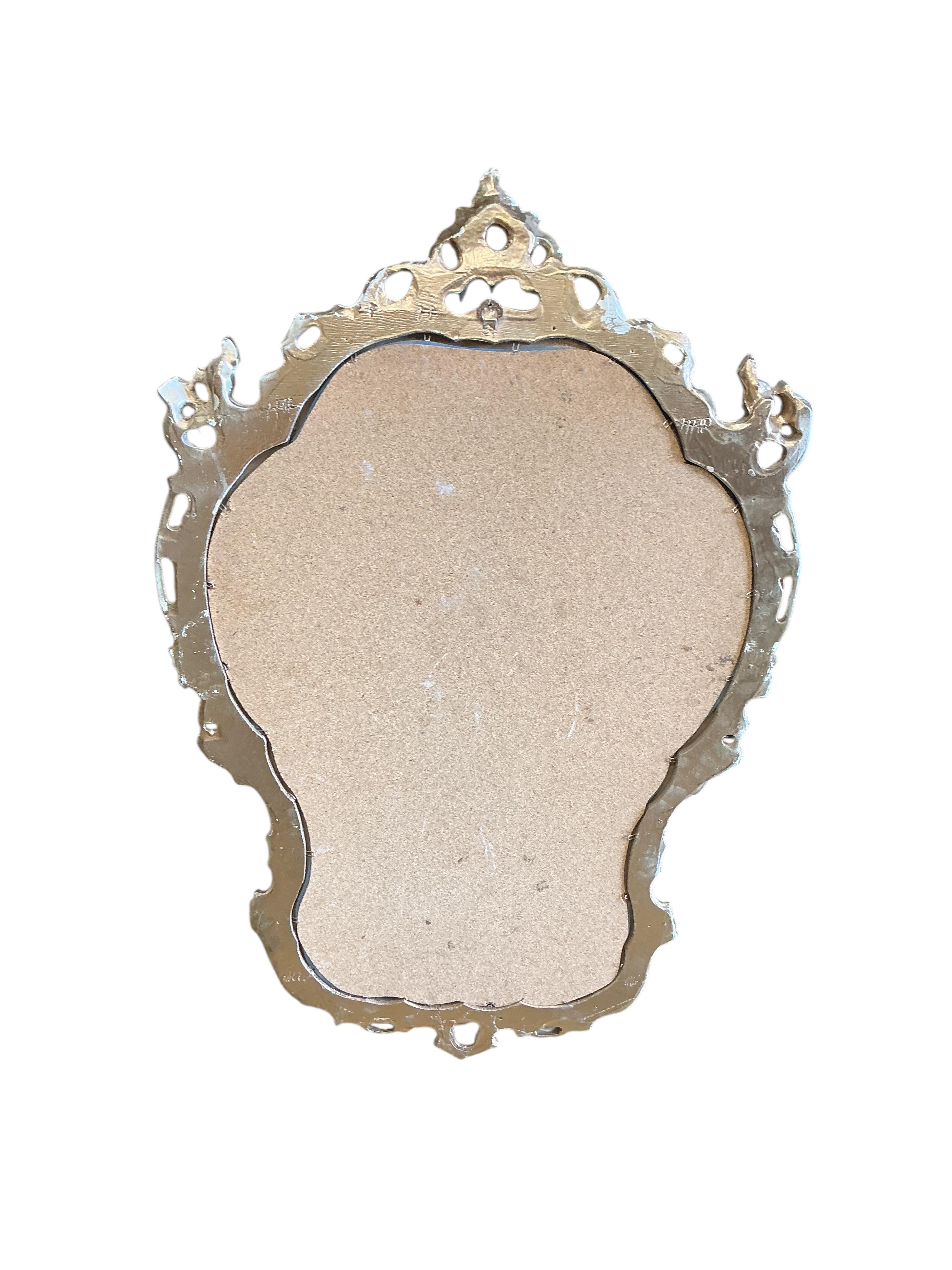 A gilt composition cherub column console table with faux marble top and a similar wall mirror, table width 73cm, depth 26cm, height 83cm.
